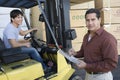 Man Writing On A Clipboard With Worker Driving Forktruck At Warehouse Royalty Free Stock Photo