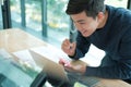 Man writing reminder on sticky note. male freelancer student working organizing plan at workplace Royalty Free Stock Photo