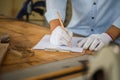 Man writing some notes on paper, Carpenter working on woodworking machines in carpentry shop