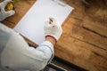 Man writing some notes on paper, Carpenter working on woodworking machines in carpentry shop, Workbench with copy space