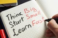 Man is writing Think big, start small, learn fast. Royalty Free Stock Photo