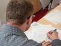 A man writing up paperwork at work.