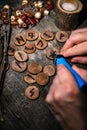 Man writing wooden runes with an pyrography or pokerwork, esoteric background