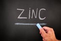 Man writing the word Zinc on a chalkboard