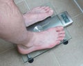 Man& x27;s feet on weight scale - Eat healthy
