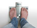 Man& x27;s feet on weight scale - OMG Royalty Free Stock Photo