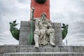 A man's figure with two rostra sitting at the foot of the rostrum column on the Spit of Vasilievsky Island. Royalty Free Stock Photo