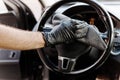 Man& x27;s hand in black glove cleaning car interior, dashboard and leather seats with microfiber cloth Royalty Free Stock Photo