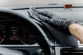 Man& x27;s hand in black glove cleaning car interior, dashboard and leather seats with microfiber cloth Royalty Free Stock Photo