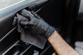 Man& x27;s hand in black glove cleaning car interior, dashboard and leather seats with microfiber cloth Royalty Free Stock Photo