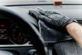 Man& x27;s hand in black glove cleaning car interior, dashboard and leather seats with microfiber cloth Royalty Free Stock Photo