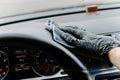 Man& x27;s hand in black glove cleaning car interior, dashboard and leather seats with microfiber cloth Royalty Free Stock Photo