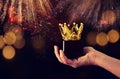 Man& x27;s hand holding crown award trophy for show victory or winning first place. Glitter overlay. Royalty Free Stock Photo