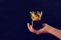 Man& x27;s hand holding crown award trophy for show victory or winning first place. Glitter overlay. Royalty Free Stock Photo