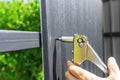 A worker puts rivets into a profiled sheet on a fence.