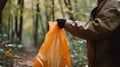 Man& x27;s hand holding trash bag in the forest Royalty Free Stock Photo