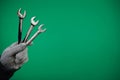 Man& x27;s hand holds a spanners isolated advertising Green background chromakey free space. Close up. High resolution Royalty Free Stock Photo