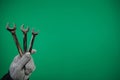 Man& x27;s hand holds a spanners isolated advertising Green background chromakey free space. Close up. High resolution Royalty Free Stock Photo