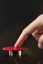 A man& x27;s hand presses a big red button. Red button on a dark background. The threat of using nuclear or chemical