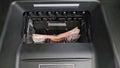 A man's hand puts five-thousand-dollar bills into an ATM bill acceptor.