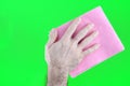A man& x27;s hand in a yellow rubber glove oil polishes the wooden surface of the table, the floor with a pink rag Royalty Free Stock Photo