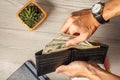 Man& x27;s hands holding black leather wallet full of dollar bills Royalty Free Stock Photo