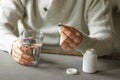 Man& x27;s hands holds a blue capsule and glass of water over the table, ready to take medicines. Health care concept. Royalty Free Stock Photo