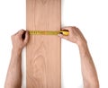 Man's hands measuring wooden plank with a tape line isolated on white background Royalty Free Stock Photo