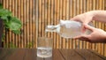 Man& x27;s hands pouring fresh pure water from bottle into glass on table. Cinematic shot of pure water into glass in Royalty Free Stock Photo