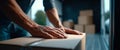 Close-up of hands pressing down on a cardboard box inside a delivery van with stacked packages in the background Royalty Free Stock Photo