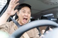 A man is yelling in a car is driving a car and looking at his cell phone. He is surprised and excited Royalty Free Stock Photo