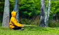 Man in yellow hoodie is relaxingly practicing meditation in the forest to attain happiness from inner peace wisdom for healthy