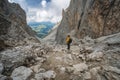 Man in yellow jacket and backpack at Pass on Mountain Sassolungo - Langkofel, Alpe di Siusi, Dolomiti mountain - South