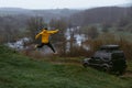 A man in a yellow jacket win jump. Off-road vehicle. A small compact car for extreme hobbies and recreation in wilderness. River