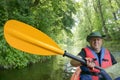 Man with yellow paddle in boat, a man in a red vest on a kayak Royalty Free Stock Photo