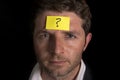 Man with yellow postit note on his forehead Royalty Free Stock Photo