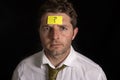 Man with yellow postit note on his forehead Royalty Free Stock Photo