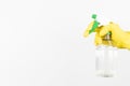 Man with yellow protective glove holding spray bottle for sanitization on white background. Wiping down surface concept