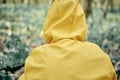 Man in a yellow raincoat with a hood in the forest. Close up shot
