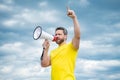 man in yellow shirt agitate in loudspeaker on sky background Royalty Free Stock Photo