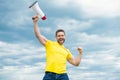 man in yellow shirt with megaphone on sky background. last chance