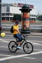 A man in yellow t-shirt rides a bycicle