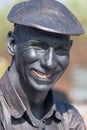 Man with yellow teeth and grey face paint smiling