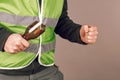 Man in a yellow vest protesting with a broken bottle in his hands