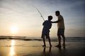 Man and young boy fishing in surf Royalty Free Stock Photo
