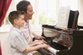 Man and young boy playing piano and smiling Royalty Free Stock Photo