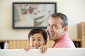 Man and young boy in room with flat screen