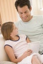 Man and young girl in living room reading book Royalty Free Stock Photo