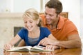 Man and young girl reading book in dining room Royalty Free Stock Photo