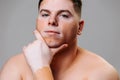 Man young vitiligo poses gray background in studio showing the beauty of the body affected disease.